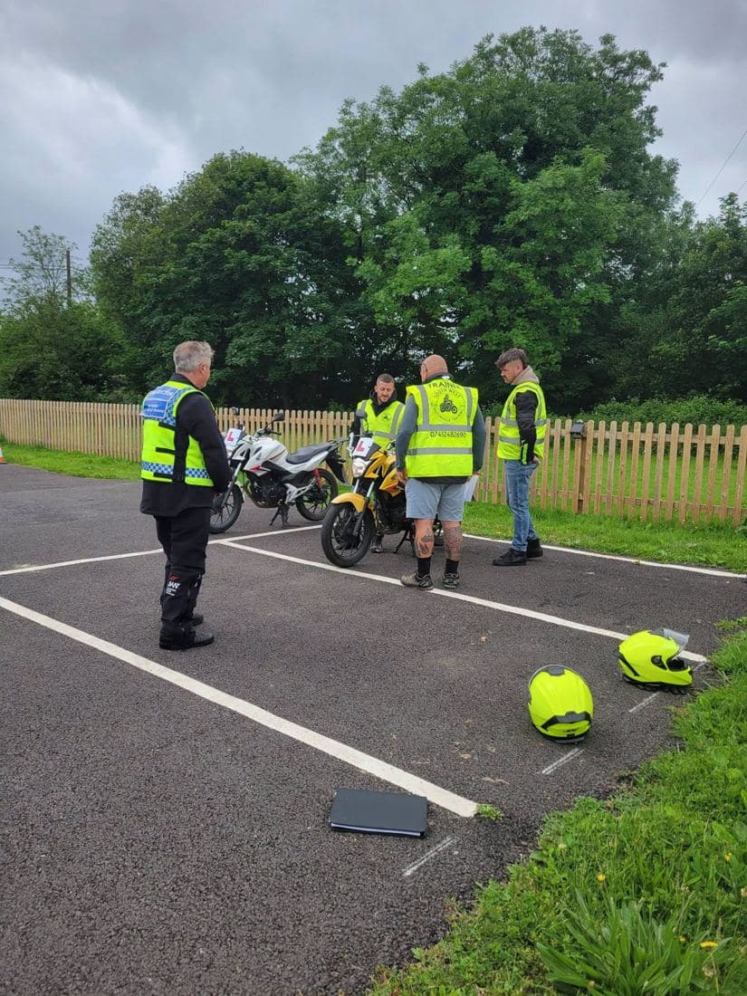 A South West Motorcycle Training instructor briefing riders beside L-plated training bikes on the marked manoeuvring pad
